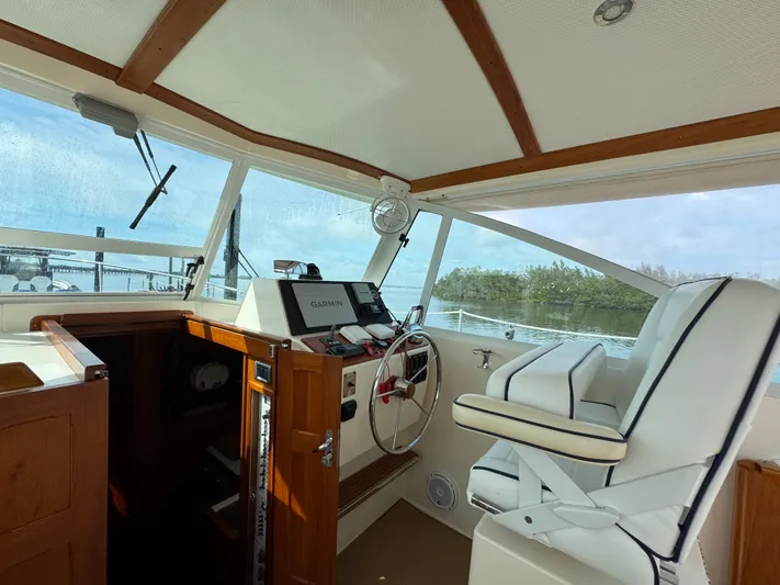 C'est La Vie Yacht Photos Pics Interior of 2010 Bruckmann Bluestar 29.9 boat showing helm and seating area.