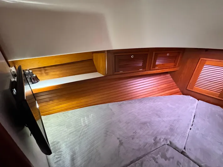 C'est La Vie Yacht Photos Pics Interior cabin of 2010 Bruckmann Bluestar 29.9 with wood paneling and cozy bedding.