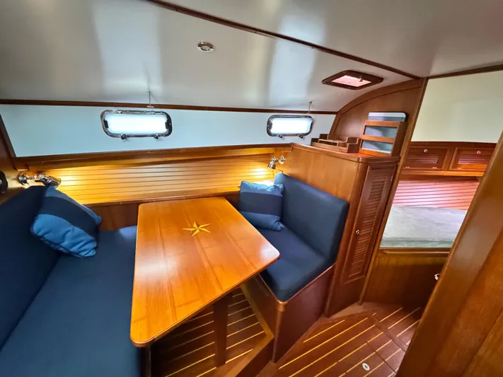 C'est La Vie Yacht Photos Pics Interior of 2010 Bruckmann Bluestar 29.9 yacht with wooden table and blue seating.