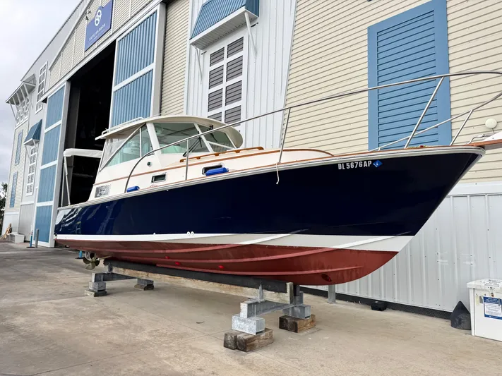 C'est La Vie Yacht Photos Pics 2010 Bruckmann Bluestar 29.9 boat on stands outside a large storage facility.