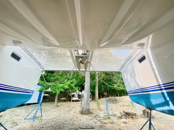 Ronin Yacht Photos Pics 2016 Celtic Yachts 40 catamaran on stands, viewed from below, with trees in the background.