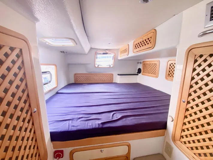 Ronin Yacht Photos Pics Cozy cabin interior of 2016 Celtic Yachts 40 with lattice wood accents and purple bedding.