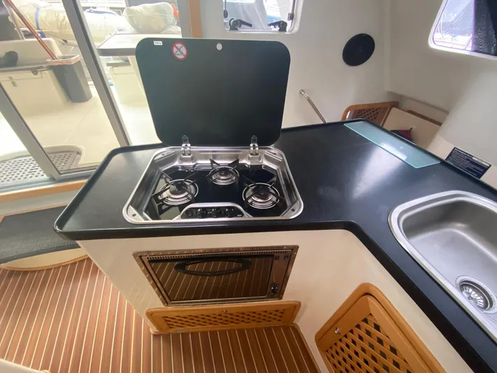 Ronin Yacht Photos Pics Celtic Yachts 40 (2016) kitchen area with stove, sink, and wooden flooring.