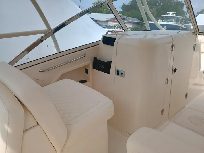  Yacht Photos Pics 2025 Grady-White Freedom 275 boat interior with beige seating and storage compartments.