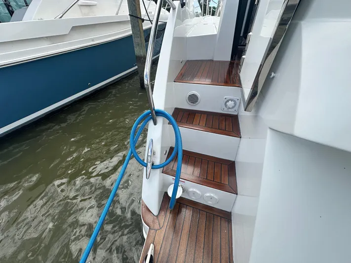 Sea Addendum Yacht Photos Pics 2021 Galeon 425 HTS yacht with wooden steps and blue rope by the water.