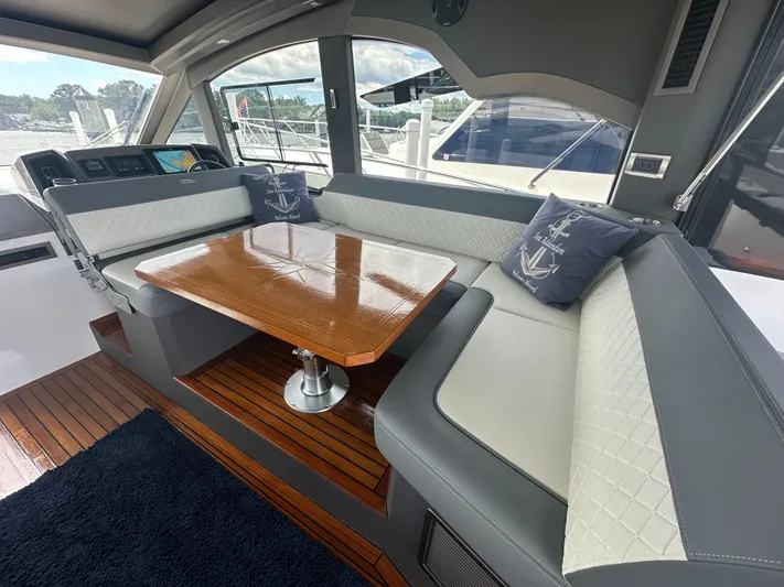 Sea Addendum Yacht Photos Pics Interior of 2021 Galeon 425 HTS yacht with elegant seating and wooden table.