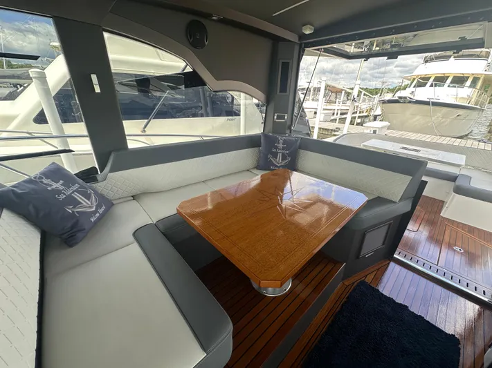 Sea Addendum Yacht Photos Pics Interior of 2021 Galeon 425 HTS yacht with elegant seating and wooden table.
