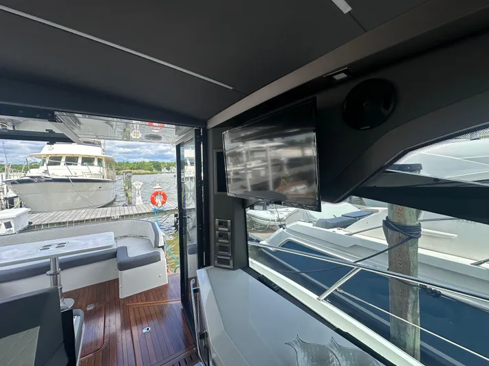 Sea Addendum Yacht Photos Pics Interior view of 2021 Galeon 425 HTS yacht with outdoor seating and docked boats.