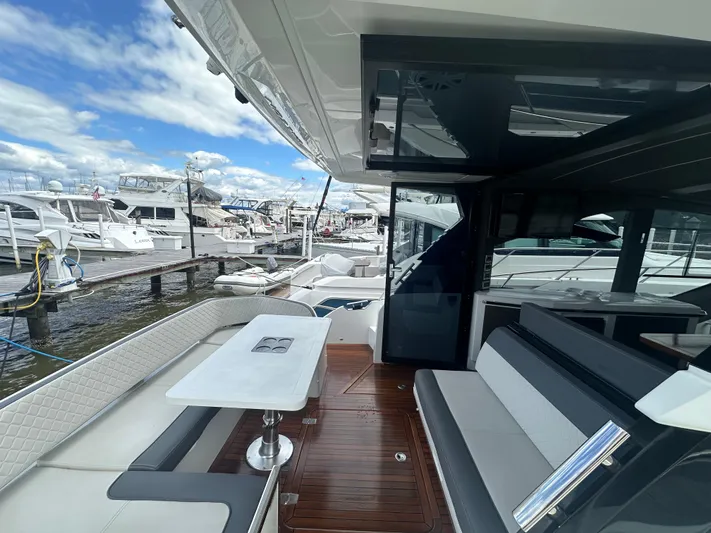 Sea Addendum Yacht Photos Pics 2021 Galeon 425 HTS yacht interior with sleek seating and table, docked at marina.