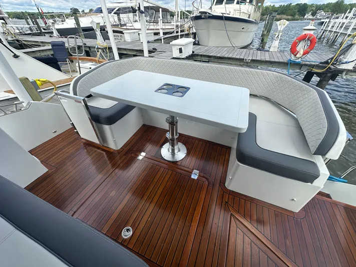 Sea Addendum Yacht Photos Pics Luxury seating area on 2021 Galeon 425 HTS yacht with wooden deck and table.