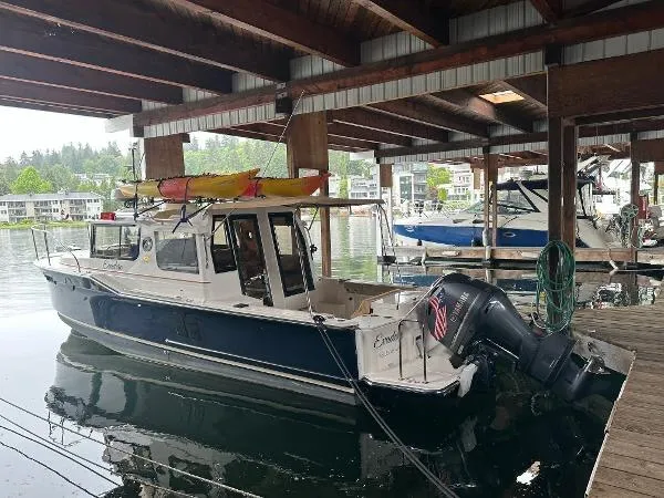 Yacht Photos Pics 2021 Ranger Tugs R-27 boat docked under a wooden shelter with a kayak on top.