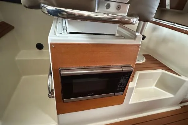  Yacht Photos Pics 2021 Ranger Tugs R-27 interior with built-in microwave and wooden accents.