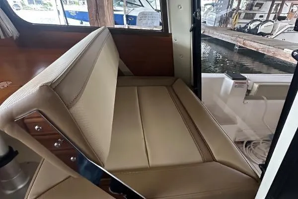  Yacht Photos Pics Interior seating of 2021 Ranger Tugs R-27 boat, featuring beige upholstery and wooden accents.