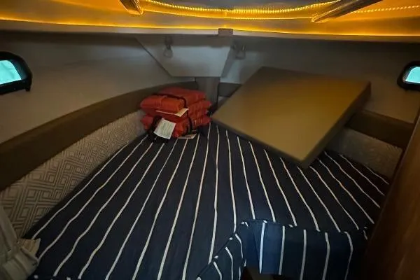  Yacht Photos Pics Cozy cabin interior of 2021 Ranger Tugs R-27 with striped bedding and ambient lighting.