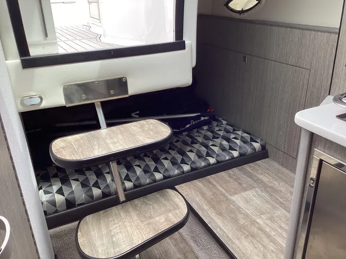 Pat.pending Yacht Photos Pics Interior of 2022 Monterey 295 Sport Yacht with modern wood finish and geometric-patterned seating.