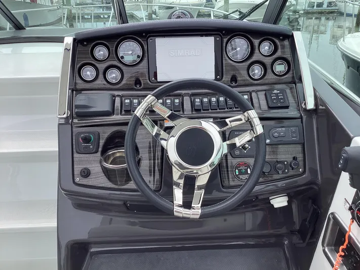 Pat.pending Yacht Photos Pics 2022 Monterey 295 Sport Yacht dashboard with modern controls and sleek steering wheel.