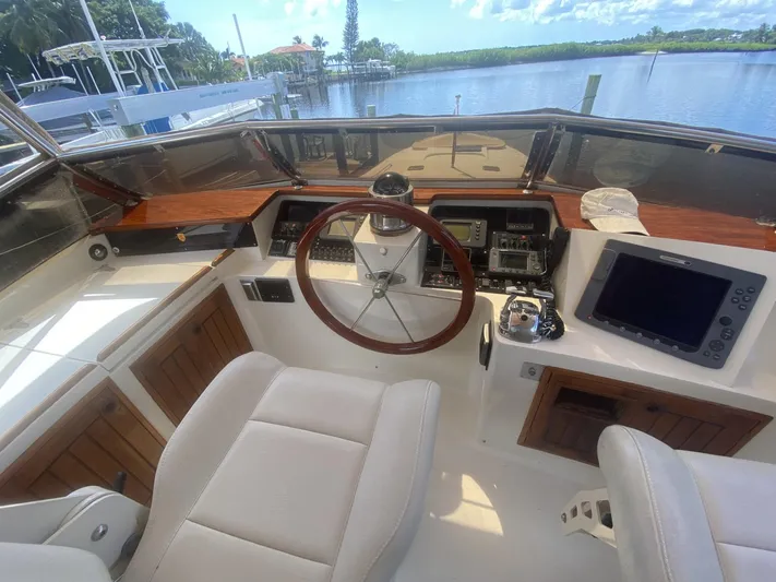 Sirena Yacht Photos Pics 1986 Midnight Lace 52 Flybridge helm with wooden accents and modern navigation equipment.