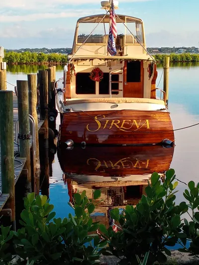 Sirena Yacht Photos Pics 1986 Midnight Lace 52 Flybridge yacht "Sirena" docked, reflecting on calm water.