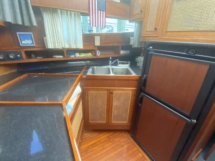 Sirena Yacht Photos Pics 1986 Midnight Lace 52 Flybridge yacht kitchen with wood cabinetry and dual sink.