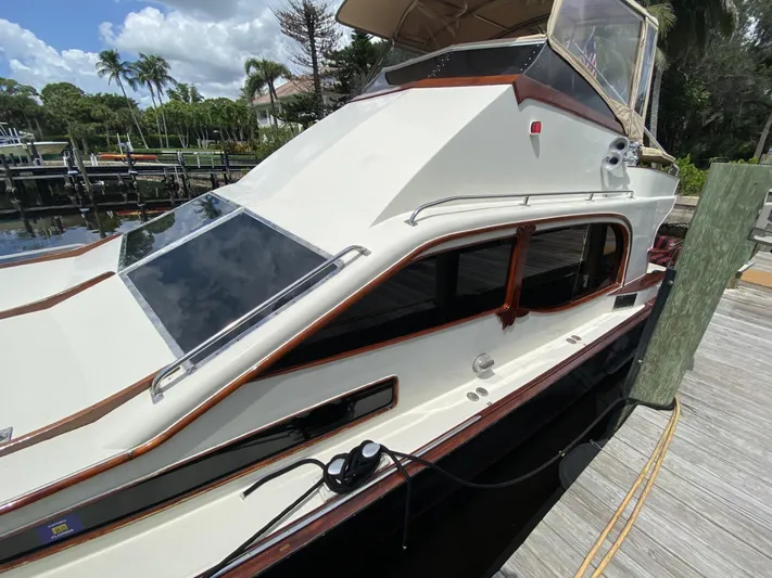 Sirena Yacht Photos Pics 1986 Midnight Lace 52 Flybridge yacht docked, featuring sleek design and elegant detailing.
