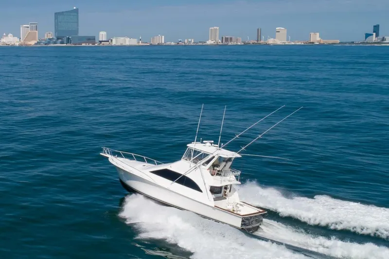  Yacht Photos Pics 1999 Ocean Yachts 48 Super Sport cruising near city skyline on open water.