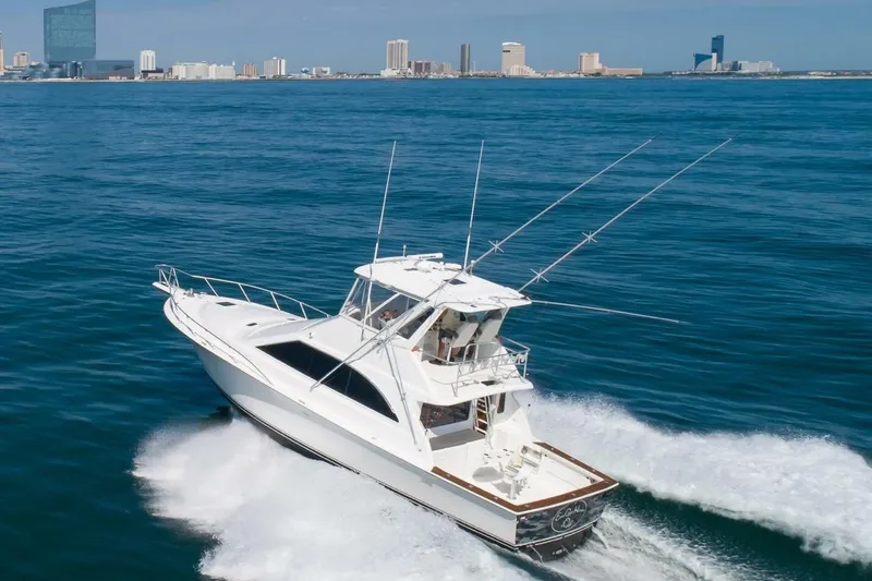  Yacht Photos Pics 1999 Ocean Yachts 48 Super Sport cruising on open water near city skyline.