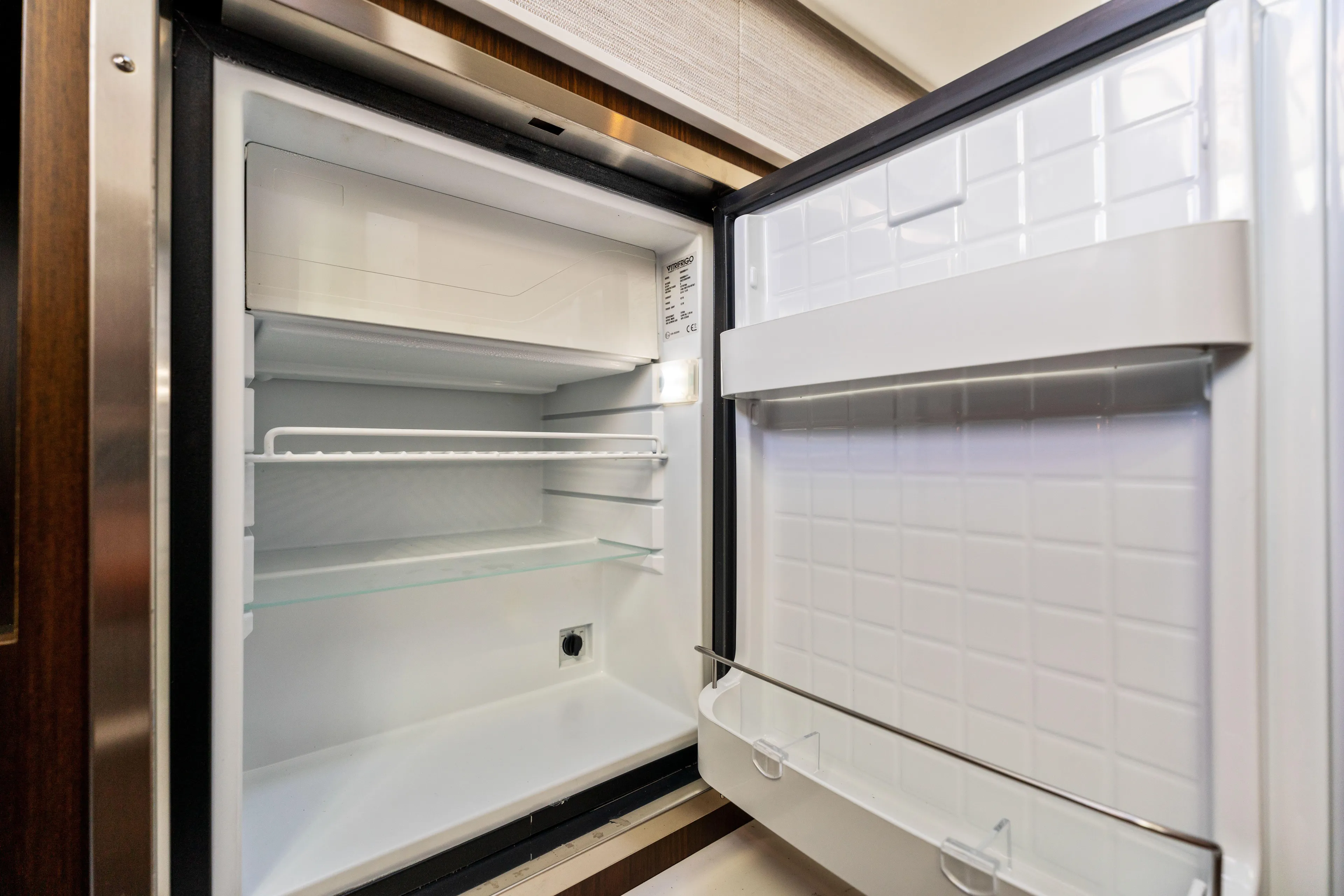  Yacht Photos Pics Open refrigerator inside 2026 Cruisers Yachts 34 GLS OB, showcasing spacious interior.