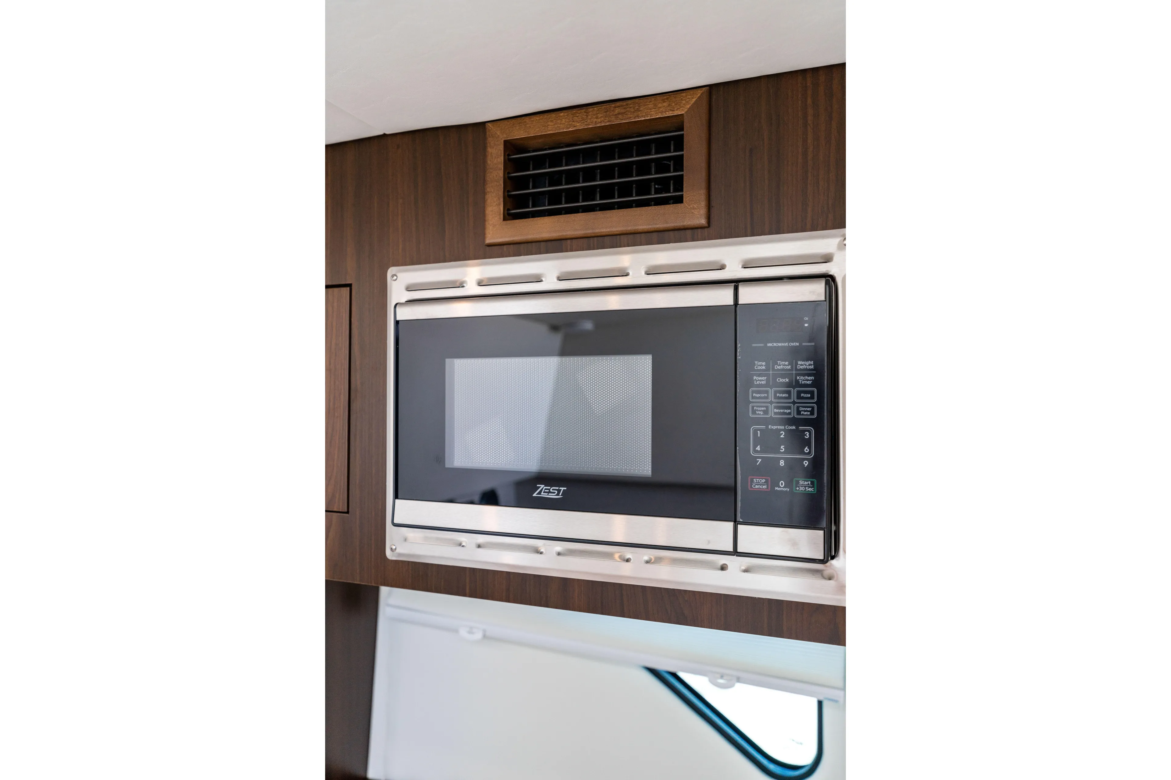  Yacht Photos Pics Built-in microwave in 2026 Cruisers Yachts 34 GLS OB, featuring sleek wood paneling.