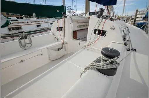 J/111 Yacht Photos Pics 2013 J Boats J/111 sailboat deck with ropes and winches in a marina setting.