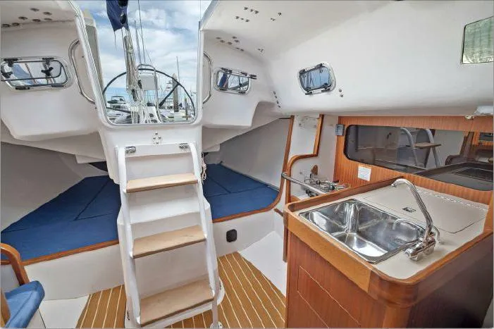 J/111 Yacht Photos Pics Interior of 2013 J Boats J/111 sailboat with wooden flooring and compact kitchen area.