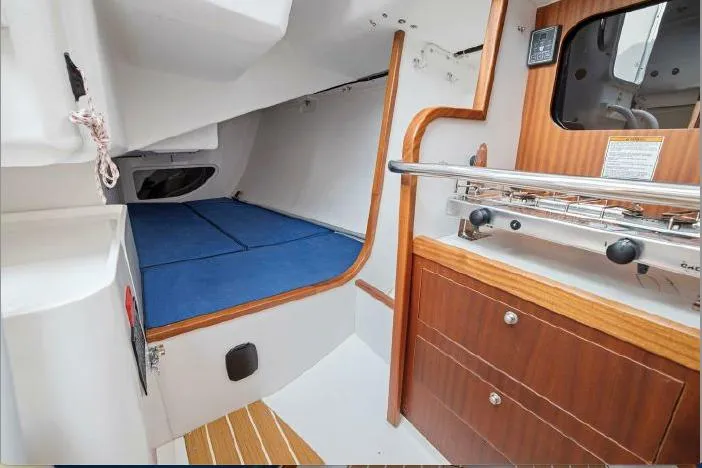 J/111 Yacht Photos Pics Interior of 2013 J Boats J/111 sailboat with blue bedding and wooden cabinetry.
