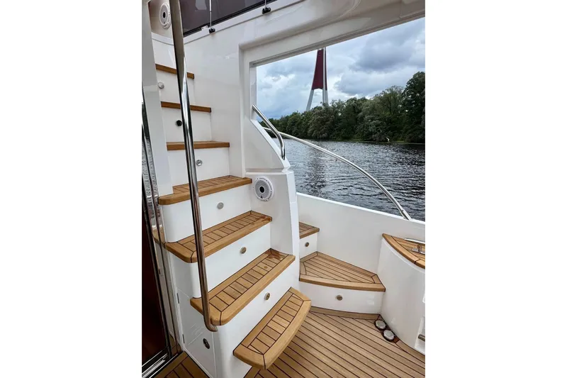  Yacht Photos Pics Luxurious 2022 Princess F50 yacht with elegant wooden stairs and scenic river view.