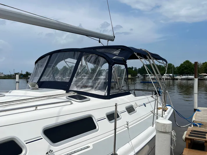  Yacht Photos Pics 2004 Hunter 41 sailboat docked, featuring a blue canopy and sleek design.