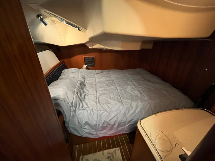  Yacht Photos Pics Cozy cabin interior of 2004 Hunter 41 sailboat with bed and wooden paneling.