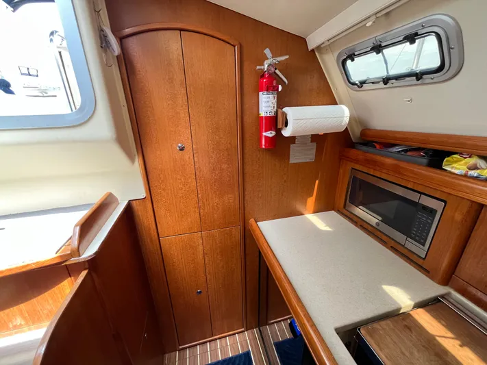  Yacht Photos Pics Interior of 2004 Hunter 41 sailboat with wood cabinetry, microwave, and fire extinguisher.