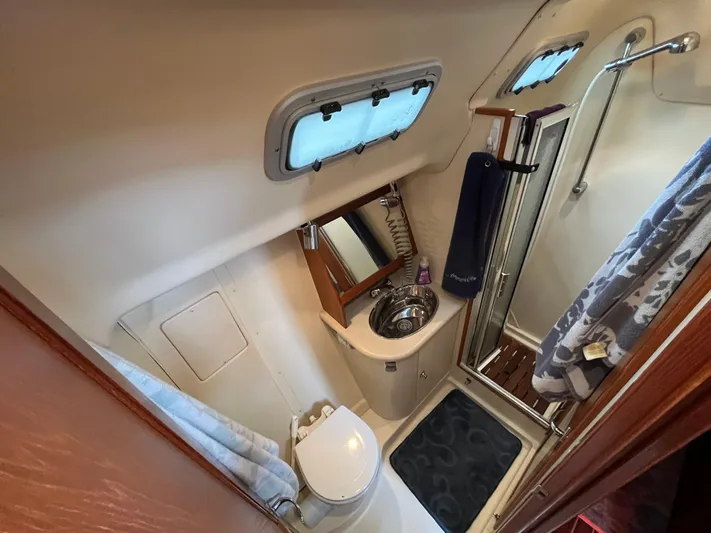  Yacht Photos Pics Compact bathroom in a 2004 Hunter 41 sailboat with shower, sink, and toilet.