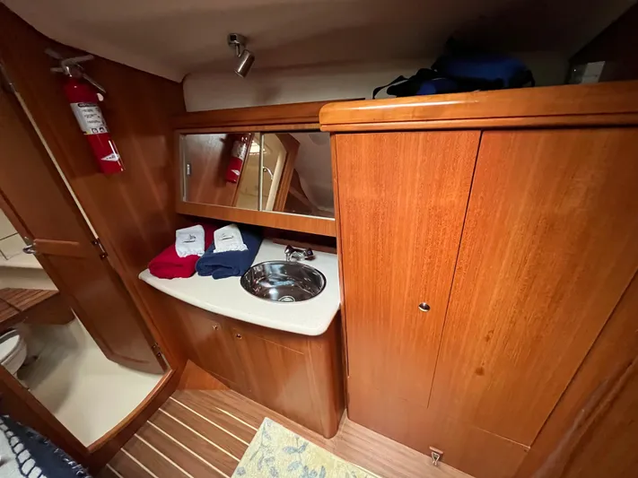  Yacht Photos Pics Interior of a 2004 Hunter 41 sailboat bathroom with wooden cabinetry and a stainless steel sink.