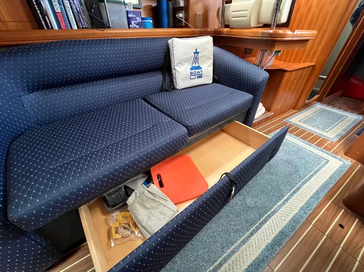  Yacht Photos Pics 2004 Hunter 41 sailboat interior with blue cushioned seating and storage drawer open.