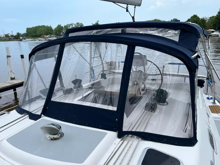  Yacht Photos Pics 2004 Hunter 41 sailboat with blue canopy docked on a calm lake.