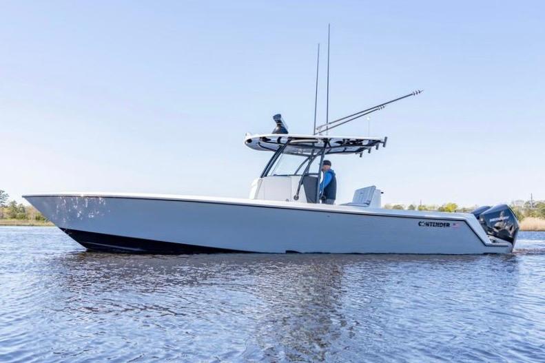 2022 Contender 32 ST boat on calm water, side view, clear sky.