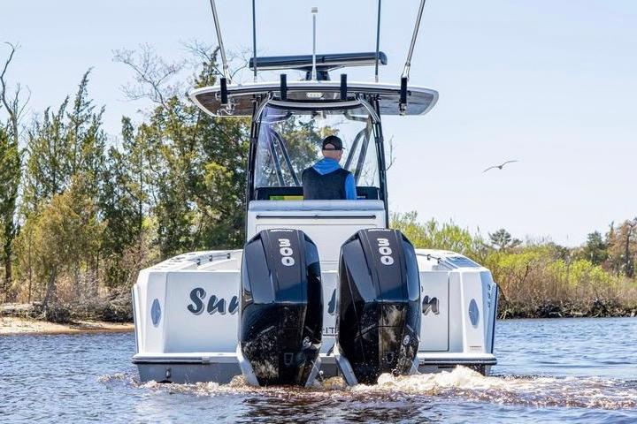 2022 Contender 32 ST boat with dual 300 horsepower engines on a scenic waterway.