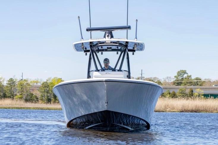2022 Contender 32 ST boat cruising on a calm waterway, front view.