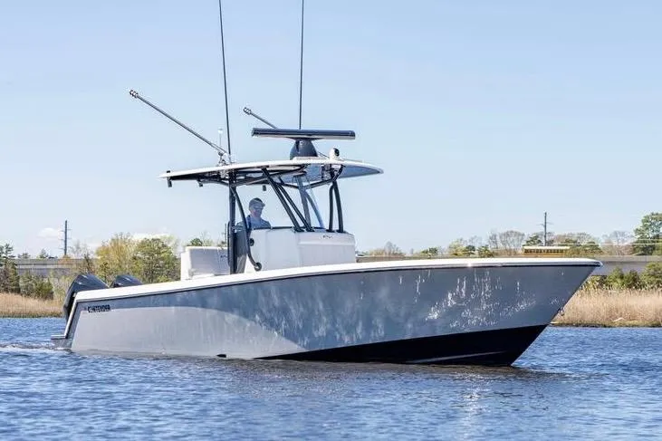  Yacht Photos Pics 2022 Contender 32 ST boat cruising on a calm waterway under clear skies.