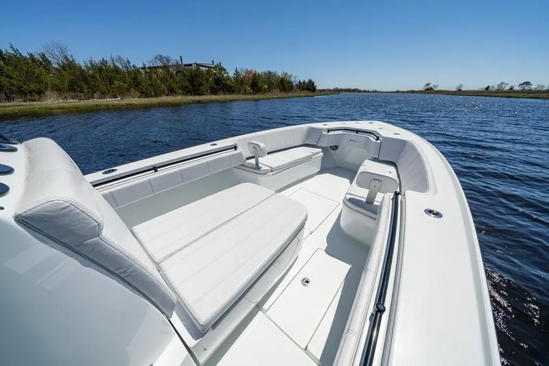  Yacht Photos Pics 2022 Contender 32 ST boat with white seating on a calm lake.