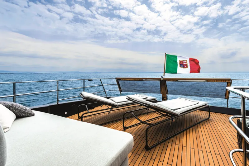  Yacht Photos Pics Luxurious deck of 2026 Cranchi Settantotto 78 yacht with sun loungers and Italian flag.