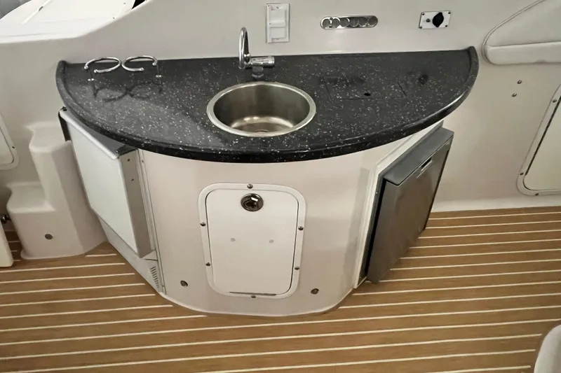 Belle Journee Yacht Photos Pics 2008 Four Winns V378 boat kitchenette with sink, countertop, and storage on wooden flooring.