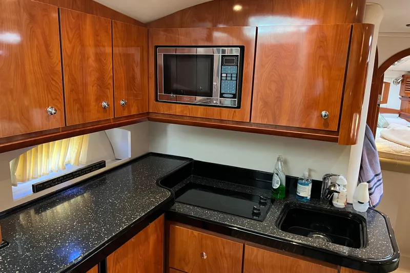 Belle Journee Yacht Photos Pics Luxurious 2008 Four Winns V378 yacht kitchen with wood cabinets and modern appliances.