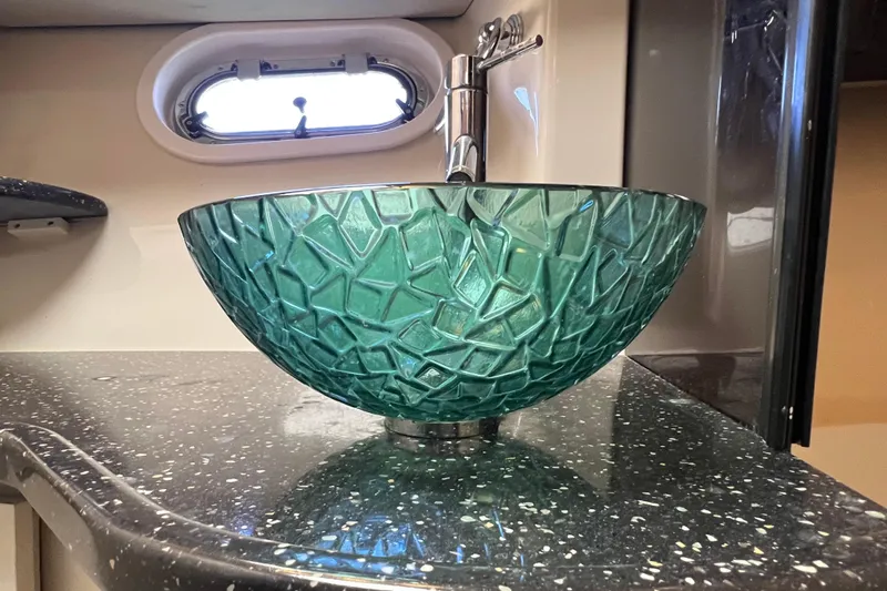 Belle Journee Yacht Photos Pics Green glass vessel sink on a speckled countertop in a 2008 Four Winns V378 boat.