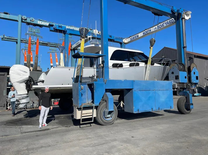 Nirvana Yacht Photos Pics 2020 Coastal Craft 33 Express yacht in boatyard lift, clear blue sky background.