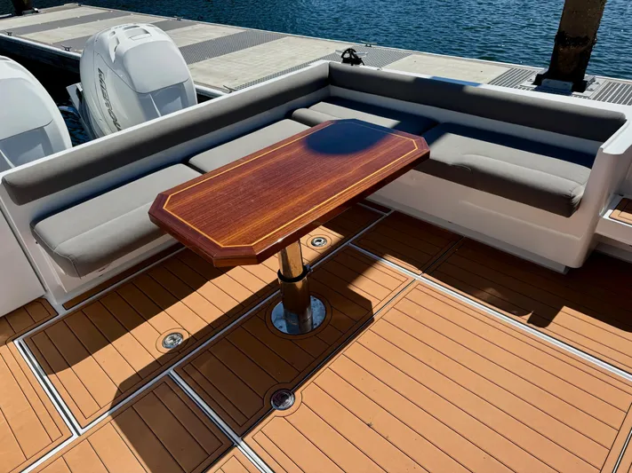 Nirvana Yacht Photos Pics Coastal Craft 33 Express 2020 boat interior with wooden table and cushioned seating.